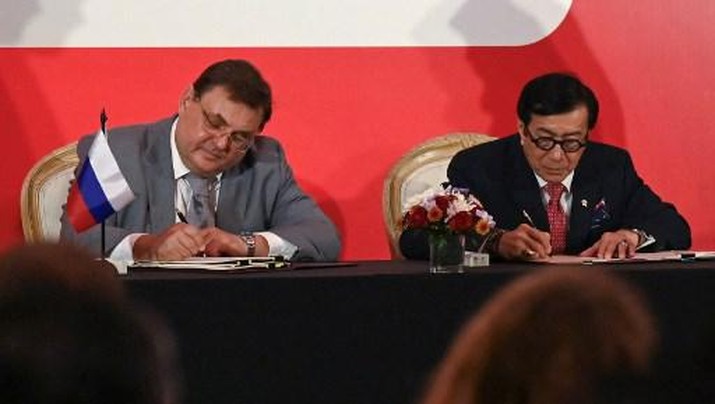 INDONESIA-RUSSIA-DIPLOMACY Indonesian Justice Minister Yasonna Laoly (R) and Russian Minister of Justice Konstantin Chuychenko (L) sign a Memorandum of Understanding during their meeting in Nusa Dua on Indonesia's resort island of Bali on March 31, 2023. (Photo by SONNY TUMBELAKA / AFP)