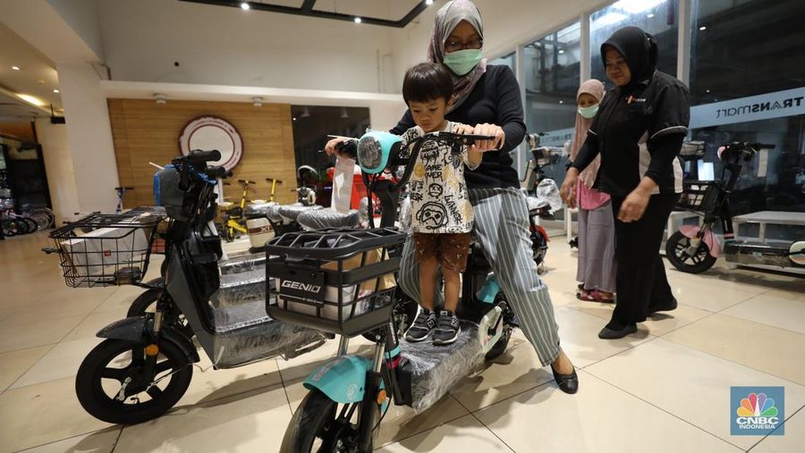 Seorang pengunjung Transmart Cempaka Putih mencoba sepeda listrik pada Rabu (15/3/2023). (CNBC Indonesia/Tri Susilo)