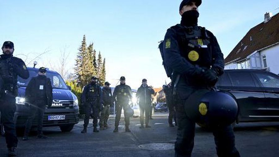 Police officers surround far-right politician Rasmus Paludan (2ndR) as he gestures in front of the Turkish Embassy in Copenhagen, on January 27, 2023. - Turkey summoned Denmark's ambassador on January 27, 2023 to condemn a protest at which far-right extremist Paludan burned the Koran over Ankara's refusal to let Sweden and Finland join NATO. (Photo by Sergei GAPON / AFP)