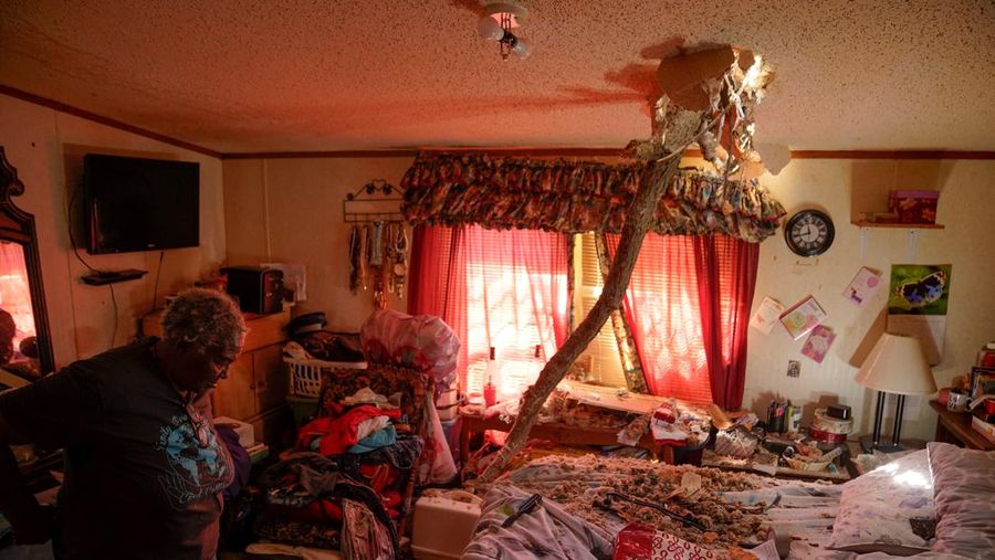 People and debris are seen through the window of a destroyed church in the aftermath of a tornado, after a monster storm system tore through the South and Midwest on Friday, in Wynne, Arkansas, U.S. April 1, 2023. REUTERS/Cheney Orr