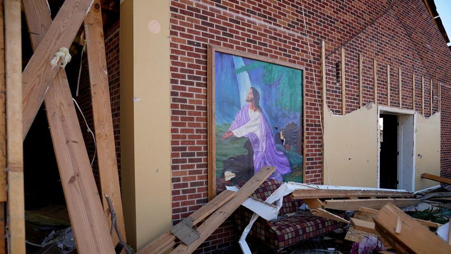 People and debris are seen through the window of a destroyed church in the aftermath of a tornado, after a monster storm system tore through the South and Midwest on Friday, in Wynne, Arkansas, U.S. April 1, 2023. REUTERS/Cheney Orr