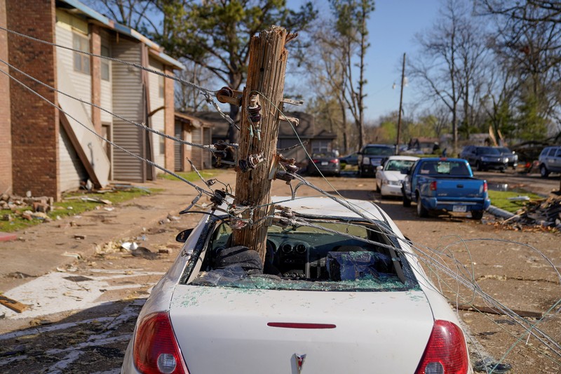 USA-WEATHER/ People and debris are seen through the window of a destroyed church in the aftermath of a tornado, after a monster storm system tore through the South and Midwest on Friday, in Wynne, Arkansas, U.S. April 1, 2023. REUTERS/Cheney Orr