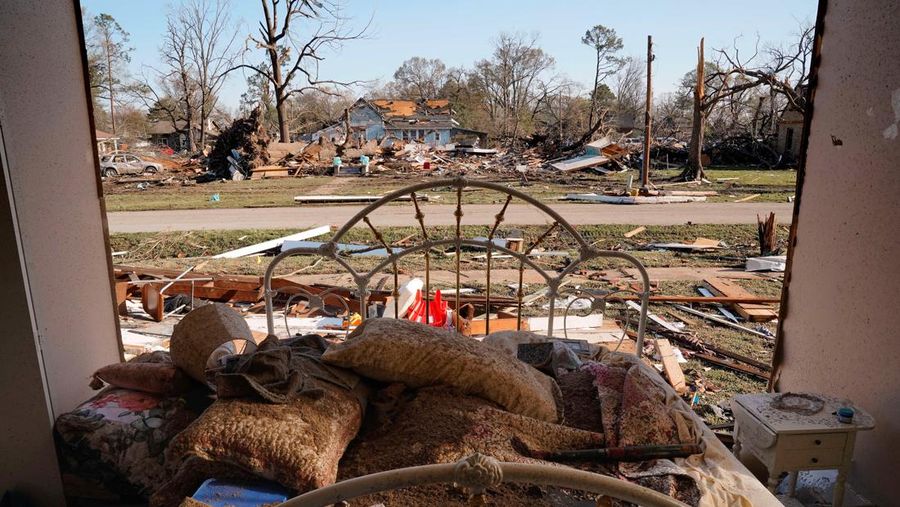 People and debris are seen through the window of a destroyed church in the aftermath of a tornado, after a monster storm system tore through the South and Midwest on Friday, in Wynne, Arkansas, U.S. April 1, 2023. REUTERS/Cheney Orr