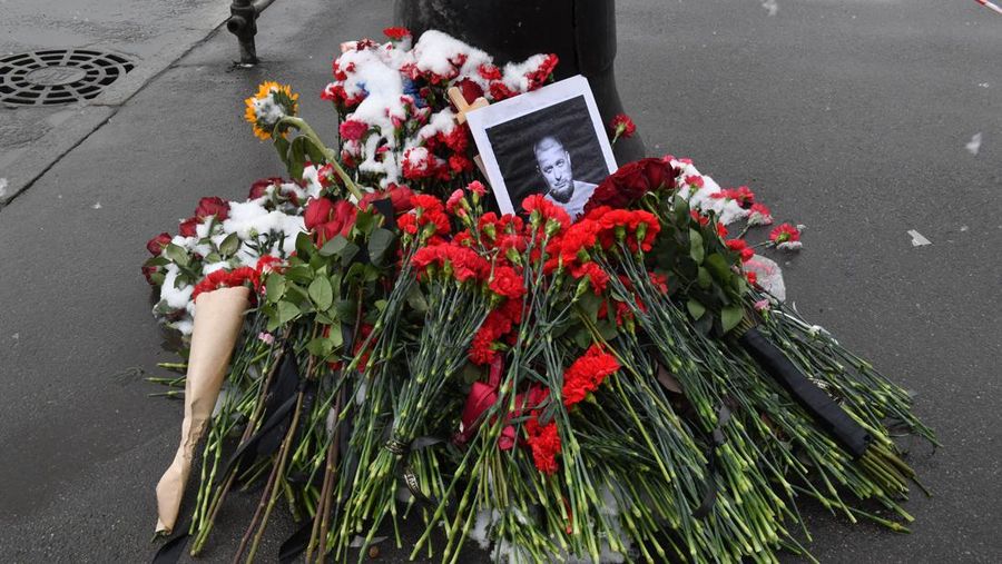 Para pria meletakkan bunga di tugu peringatan darurat untuk blogger militer Rusia Vladlen Tatarsky, yang bernama asli Maxim Fomin, yang tewas dalam ledakan bom 2 April di sebuah kafe, di lokasi ledakan di Saint Petersburg pada 3 April 2023. (OLGA MALTSEVA/AFP via Getty Images)