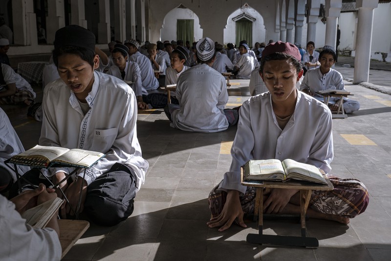 MAGETAN, INDONESIA - APRIL 02: Students learn Islamic scriptures in the Islamic boarding school Al-Fatah Temboro during the holy month of Ramadan on April 02, 2023 in Magetan, East Java, Indonesia. Al-Fatah Islamic Boarding School was founded in 1950 by KH. Kholid Umar, also known as Kyai Mahmud. Islamic boarding schools in Indonesia have around 22,000 students, including those from neighboring countries in Southeast Asia, such as Malaysia, Brunei and Thailand. The Al-Falah boarding school occupies a 50-hectare site in Temboro Village, Karas District, Magetan, East Java. It is the largest center for developing the ideology of the Tablighi Jamaat in Southeast Asia. The main goal of the Al-Fatah Islamic Boarding School is to learn about the Prophet, produce religious experts, spread Islam to all walks of life, improve oneself and uphold the da'wah journey of Allah's Apostle. The school's magnitude of the influence of religion on the lives of residents in Temboro has made this area known as the 'Village of Medina'. Students at the Pesantren, also known as 