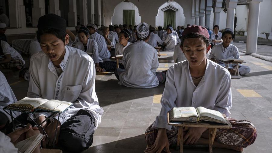 MAGETAN, INDONESIA - APRIL 02: Students learn Islamic scriptures in the Islamic boarding school Al-Fatah Temboro during the holy month of Ramadan on April 02, 2023 in Magetan, East Java, Indonesia. Al-Fatah Islamic Boarding School was founded in 1950 by KH. Kholid Umar, also known as Kyai Mahmud. Islamic boarding schools in Indonesia have around 22,000 students, including those from neighboring countries in Southeast Asia, such as Malaysia, Brunei and Thailand. The Al-Falah boarding school occupies a 50-hectare site in Temboro Village, Karas District, Magetan, East Java. It is the largest center for developing the ideology of the Tablighi Jamaat in Southeast Asia. The main goal of the Al-Fatah Islamic Boarding School is to learn about the Prophet, produce religious experts, spread Islam to all walks of life, improve oneself and uphold the da'wah journey of Allah's Apostle. The school's magnitude of the influence of religion on the lives of residents in Temboro has made this area known as the 'Village of Medina'. Students at the Pesantren, also known as 