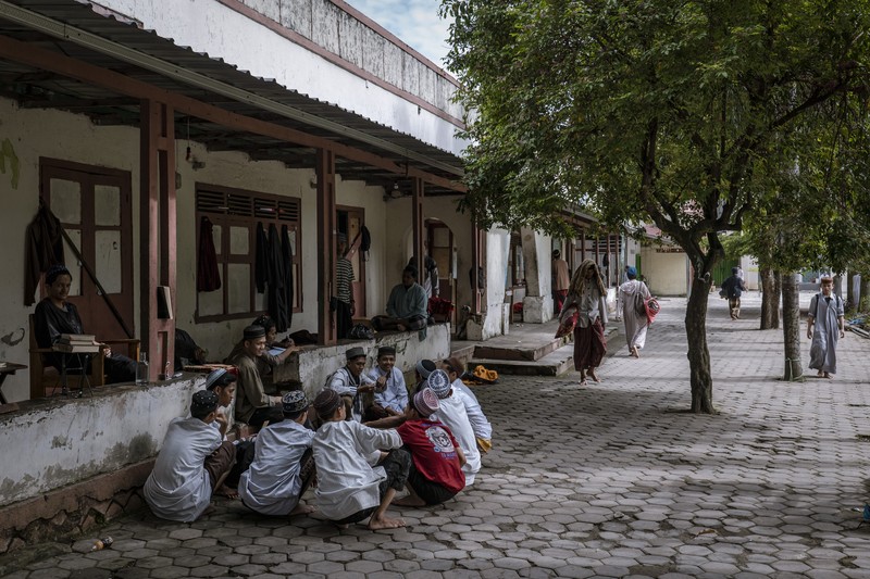 1479132692 MAGETAN, INDONESIA - APRIL 02: Students learn Islamic scriptures in the Islamic boarding school Al-Fatah Temboro during the holy month of Ramadan on April 02, 2023 in Magetan, East Java, Indonesia. Al-Fatah Islamic Boarding School was founded in 1950 by KH. Kholid Umar, also known as Kyai Mahmud. Islamic boarding schools in Indonesia have around 22,000 students, including those from neighboring countries in Southeast Asia, such as Malaysia, Brunei and Thailand. The Al-Falah boarding school occupies a 50-hectare site in Temboro Village, Karas District, Magetan, East Java. It is the largest center for developing the ideology of the Tablighi Jamaat in Southeast Asia. The main goal of the Al-Fatah Islamic Boarding School is to learn about the Prophet, produce religious experts, spread Islam to all walks of life, improve oneself and uphold the da'wah journey of Allah's Apostle. The school's magnitude of the influence of religion on the lives of residents in Temboro has made this area known as the 'Village of Medina'. Students at the Pesantren, also known as