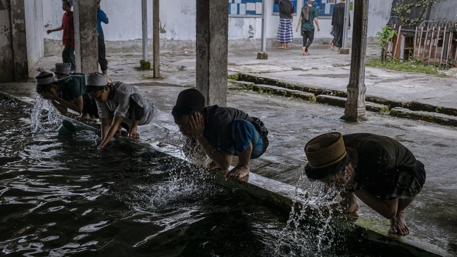 MAGETAN, INDONESIA - APRIL 02: Students clean themself before perform praying at the Islamic boarding school Al-Fatah Temboro during the holy month of Ramadan on April 02, 2023 in Magetan, East Java, Indonesia. Al-Fatah Islamic Boarding School was founded in 1950 by KH. Kholid Umar, also known as Kyai Mahmud. Islamic boarding schools in Indonesia have around 22,000 students, including those from neighbouring countries in Southeast Asia, such as Malaysia, Brunei and Thailand. The Al-Falah boarding school occupies a 50-hectare site in Temboro Village, Karas District, Magetan, East Java. It is the largest center for developing the ideology of the Tablighi Jamaat in Southeast Asia. The main goal of the Al-Fatah Islamic Boarding School is to learn about the Prophet, produce religious experts, spread Islam to all walks of life, improve oneself and uphold the da'wah journey of Allah's Apostle. The school's magnitude of the influence of religion on the lives of residents in Temboro has made this area known as the 'Village of Medina'. Students at the Pesantren, also known as