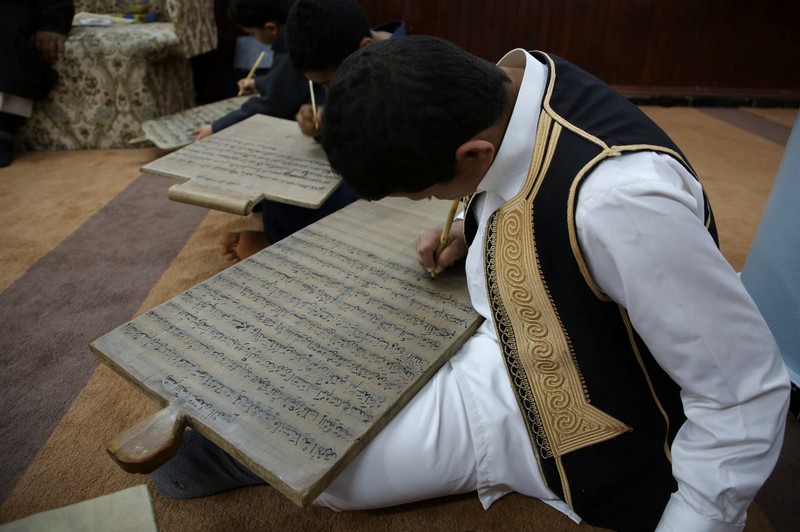 Boys recite Koran verses from wooden boards in a mosque during the Muslim holy fasting month of Ramadan, in Tripoli, Libya April 3, 2023. REUTERS/Hazem Ahmed