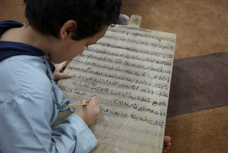 Boys recite Koran verses from wooden boards in a mosque during the Muslim holy fasting month of Ramadan, in Tripoli, Libya April 3, 2023. REUTERS/Hazem Ahmed