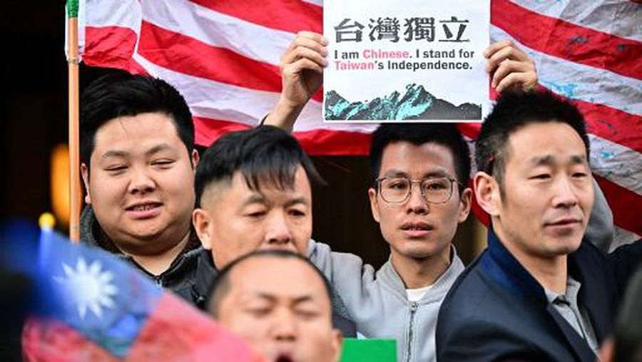 A supporter of Taiwan holds a sign reading