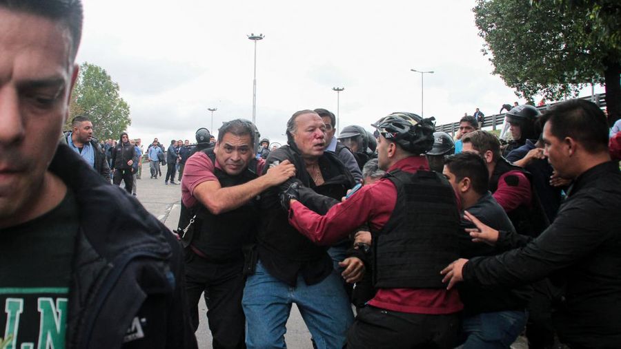 Menteri Keamanan provinsi Buenos Aires, Sergio Berni dilindungi oleh polisi dilindungi setelah dipukuli oleh sekelompok pengemudi bus yang memprotes pembunuhan seorang rekannya di La Matanza, Buenos Aires, (3/4/2023). (AFP via Getty Images/ANDRES PELOZO)