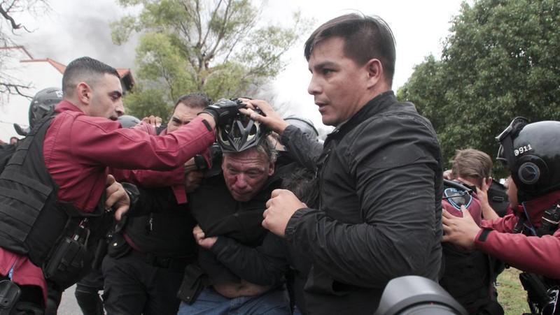 Menteri Keamanan provinsi Buenos Aires, Sergio Berni dilindungi oleh polisi dilindungi setelah dipukuli oleh sekelompok pengemudi bus yang memprotes pembunuhan seorang rekannya di La Matanza, Buenos Aires, (3/4/2023). (AFP via Getty Images/ANDRES PELOZO)