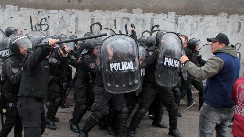 Menteri Keamanan provinsi Buenos Aires, Sergio Berni dilindungi oleh polisi dilindungi setelah dipukuli oleh sekelompok pengemudi bus yang memprotes pembunuhan seorang rekannya di La Matanza, Buenos Aires, (3/4/2023). (AFP via Getty Images/ANDRES PELOZO)