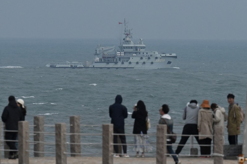 Helikopter militer China terbang melewati turis di titik pandang di atas Selat Taiwan, di pulau Pingtan, titik terdekat ke Taiwan, di provinsi Fujian tenggara China pada 7 April 2023. Helikopter militer China terbang melewati turis di titik pandang di atas Selat Taiwan, di pulau Pingtan, titik terdekat ke Taiwan, di provinsi Fujian tenggara China pada 7 April 2023. (GREG BAKER/AFP via Getty Images)