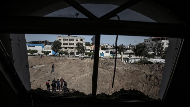 Warga Palestina memeriksa rumah mereka yang hancur setelah Israel melancarkan serangan udara di kantong Palestina. Israel melancarkan serangan udara sebelum fajar pada 7 April 2023 di Jalur Gaza dan Lebanon, mengatakan pihaknya menargetkan Hamas sebagai pembalasan atas beberapa lusin roket yang ditembakkan ke Israel dari kedua wilayah tersebut. Militer Israel telah menyerang sasaran di Jalur Gaza, mendorong wilayah itu ke arah kebakaran yang lebih luas setelah seharian tembakan roket di sepanjang perbatasan utara dan selatan negara itu. Pertempuran itu terjadi setelah kerusuhan selama dua hari di tempat suci paling sensitif di Yerusalem. Ketika pesawat Israel mulai menyerang Gaza, militan Palestina dengan cepat menembakkan rentetan roket baru, memicu sirene serangan udara melintasi Israel selatan.(Ahmed Zakot/SOPA Images/LightRocket via Getty Images)