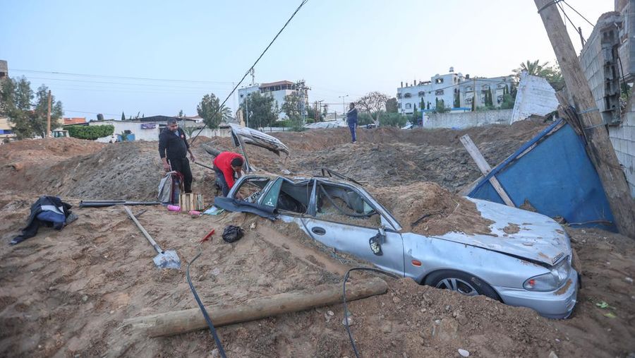 Warga Palestina memeriksa rumah mereka yang hancur setelah Israel melancarkan serangan udara di kantong Palestina. Israel melancarkan serangan udara sebelum fajar pada 7 April 2023 di Jalur Gaza dan Lebanon, mengatakan pihaknya menargetkan Hamas sebagai pembalasan atas beberapa lusin roket yang ditembakkan ke Israel dari kedua wilayah tersebut. Militer Israel telah menyerang sasaran di Jalur Gaza, mendorong wilayah itu ke arah kebakaran yang lebih luas setelah seharian tembakan roket di sepanjang perbatasan utara dan selatan negara itu. Pertempuran itu terjadi setelah kerusuhan selama dua hari di tempat suci paling sensitif di Yerusalem. Ketika pesawat Israel mulai menyerang Gaza, militan Palestina dengan cepat menembakkan rentetan roket baru, memicu sirene serangan udara melintasi Israel selatan.(Ahmed Zakot/SOPA Images/LightRocket via Getty Images)