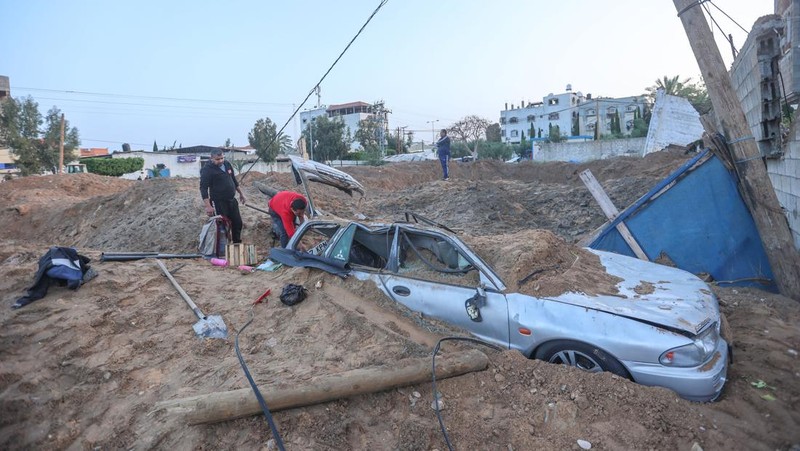 Warga Palestina memeriksa rumah mereka yang hancur setelah Israel melancarkan serangan udara di kantong Palestina. Israel melancarkan serangan udara sebelum fajar pada 7 April 2023 di Jalur Gaza dan Lebanon, mengatakan pihaknya menargetkan Hamas sebagai pembalasan atas beberapa lusin roket yang ditembakkan ke Israel dari kedua wilayah tersebut. Militer Israel telah menyerang sasaran di Jalur Gaza, mendorong wilayah itu ke arah kebakaran yang lebih luas setelah seharian tembakan roket di sepanjang perbatasan utara dan selatan negara itu. Pertempuran itu terjadi setelah kerusuhan selama dua hari di tempat suci paling sensitif di Yerusalem. Ketika pesawat Israel mulai menyerang Gaza, militan Palestina dengan cepat menembakkan rentetan roket baru, memicu sirene serangan udara melintasi Israel selatan.(Ahmed Zakot/SOPA Images/LightRocket via Getty Images)