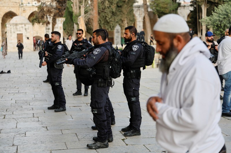 Pengunjung Yahudi berjalan melewati orang-orang yang membaca Alquran, di kompleks Masjid Al-Aqsa, yang dikenal umat Islam sebagai Tempat Suci Mulia dan bagi orang Yahudi sebagai Temple Mount, sementara ketegangan muncul selama bentrokan di Kota Tua Yerusalem, 9 April 2023. Pengunjung Yahudi berjalan melewati orang-orang yang membaca Alquran, di kompleks Masjid Al-Aqsa, yang dikenal umat Islam sebagai Tempat Suci Mulia dan bagi orang Yahudi sebagai Temple Mount, sementara ketegangan muncul selama bentrokan di Kota Tua Yerusalem, 9 April 2023. (REUTERS/Ammar Awad)