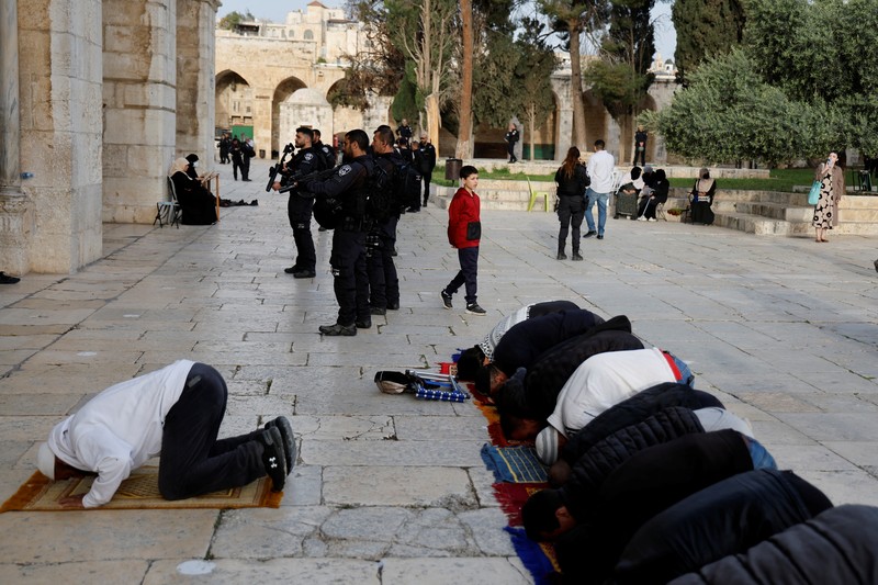 Pengunjung Yahudi berjalan melewati orang-orang yang membaca Alquran, di kompleks Masjid Al-Aqsa, yang dikenal umat Islam sebagai Tempat Suci Mulia dan bagi orang Yahudi sebagai Temple Mount, sementara ketegangan muncul selama bentrokan di Kota Tua Yerusalem, 9 April 2023. Pengunjung Yahudi berjalan melewati orang-orang yang membaca Alquran, di kompleks Masjid Al-Aqsa, yang dikenal umat Islam sebagai Tempat Suci Mulia dan bagi orang Yahudi sebagai Temple Mount, sementara ketegangan muncul selama bentrokan di Kota Tua Yerusalem, 9 April 2023. (REUTERS/Ammar Awad)