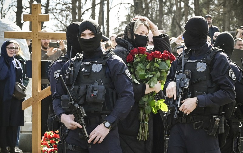Para karyawan mengubur peti mati berisi jenazah blogger militer Vladlen Tatarsky (nama asli Maxim Fomin) selama pemakaman di Moskow pada 8 April 2023. Para karyawan mengubur peti mati berisi jenazah blogger militer Vladlen Tatarsky (nama asli Maxim Fomin) selama pemakaman di Moskow pada 8 April 2023. - Ratusan pendukung hadir pada 8 April 2023, untuk pemakaman seorang petinggi Rusia blogger militer tewas dalam serangan bom. (ALEXANDER NEMENOV/AFP via Getty Images)