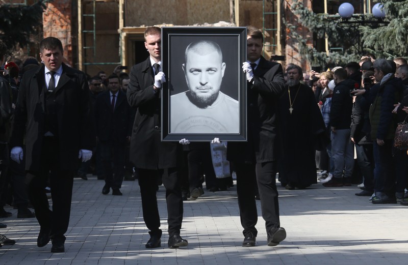 Para karyawan mengubur peti mati berisi jenazah blogger militer Vladlen Tatarsky (nama asli Maxim Fomin) selama pemakaman di Moskow pada 8 April 2023. Para karyawan mengubur peti mati berisi jenazah blogger militer Vladlen Tatarsky (nama asli Maxim Fomin) selama pemakaman di Moskow pada 8 April 2023. - Ratusan pendukung hadir pada 8 April 2023, untuk pemakaman seorang petinggi Rusia blogger militer tewas dalam serangan bom. (ALEXANDER NEMENOV/AFP via Getty Images)
