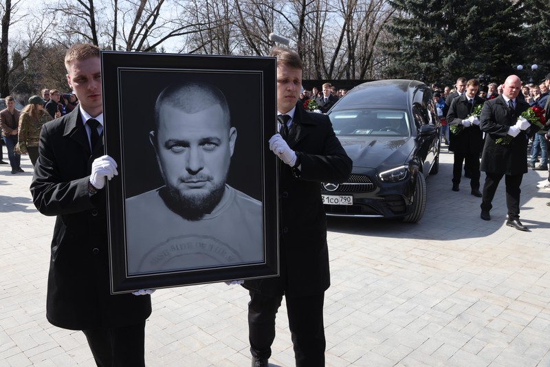 Para karyawan mengubur peti mati berisi jenazah blogger militer Vladlen Tatarsky (nama asli Maxim Fomin) selama pemakaman di Moskow pada 8 April 2023. Para karyawan mengubur peti mati berisi jenazah blogger militer Vladlen Tatarsky (nama asli Maxim Fomin) selama pemakaman di Moskow pada 8 April 2023. - Ratusan pendukung hadir pada 8 April 2023, untuk pemakaman seorang petinggi Rusia blogger militer tewas dalam serangan bom. (ALEXANDER NEMENOV/AFP via Getty Images)