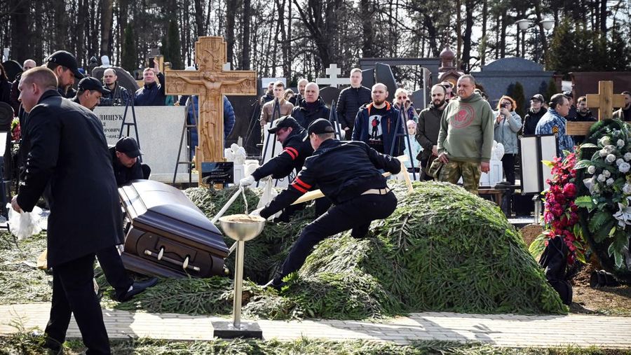Para karyawan mengubur peti mati berisi jenazah blogger militer Vladlen Tatarsky (nama asli Maxim Fomin) selama pemakaman di Moskow pada 8 April 2023. - Ratusan pendukung hadir pada 8 April 2023, untuk pemakaman seorang petinggi Rusia blogger militer tewas dalam serangan bom. (ALEXANDER NEMENOV/AFP via Getty Images)