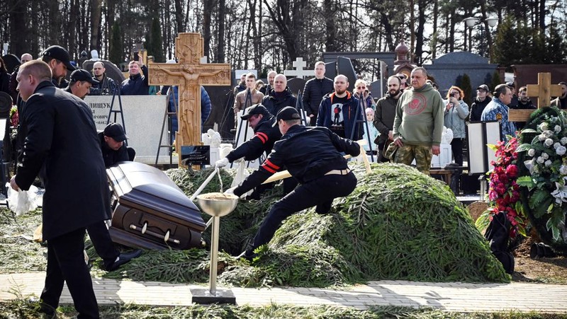 Para karyawan mengubur peti mati berisi jenazah blogger militer Vladlen Tatarsky (nama asli Maxim Fomin) selama pemakaman di Moskow pada 8 April 2023. - Ratusan pendukung hadir pada 8 April 2023, untuk pemakaman seorang petinggi Rusia blogger militer tewas dalam serangan bom. (ALEXANDER NEMENOV/AFP via Getty Images)
