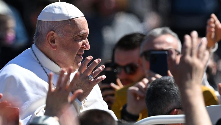 Paus Francis melambai dari mobil Popemobile saat dia melakukan tur ke alun-alun Santo Petrus setelah misa Minggu Paskah pada 9 April 2023 di Vatikan. (ANDREAS SOLARO/AFP via Getty Images)