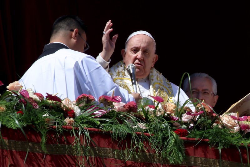 Paus Fransiskus melambai dari loggia Basilika Santo Petrus yang menghadap ke alun-alun Santo Petrus, setelah menyampaikan berkat Paskah Urbi et Orbi pada 9 April 2023 di Vatikan. Paus Fransiskus melambai dari loggia Basilika Santo Petrus yang menghadap ke alun-alun Santo Petrus, setelah menyampaikan berkat Paskah Urbi et Orbi pada 9 April 2023 di Vatikan. (ANDREAS SOLARO/AFP via Getty Images)