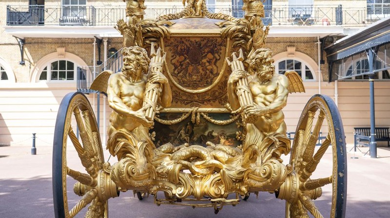 The Diamond Jubilee State Coach on display at the Royal Mews in Buckingham Palace, London, Tuesday April 4, 2023, in which King Charles III and the Queen Consort will travel to the coronation. King Charles III is taking a short cut and smoother ride to Westminster Abbey, trimming the procession route his mother took in 1953 as he aims for a more modest coronation that will include some modern touches, Buckingham Palace said Sunday April 9, 2023. (Yui Mok/PA via AP)