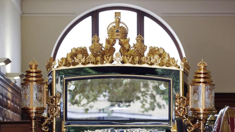 The Diamond Jubilee State Coach on display at the Royal Mews in Buckingham Palace, London, Tuesday April 4, 2023, in which King Charles III and the Queen Consort will travel to the coronation. King Charles III is taking a short cut and smoother ride to Westminster Abbey, trimming the procession route his mother took in 1953 as he aims for a more modest coronation that will include some modern touches, Buckingham Palace said Sunday April 9, 2023. (Yui Mok/PA via AP)