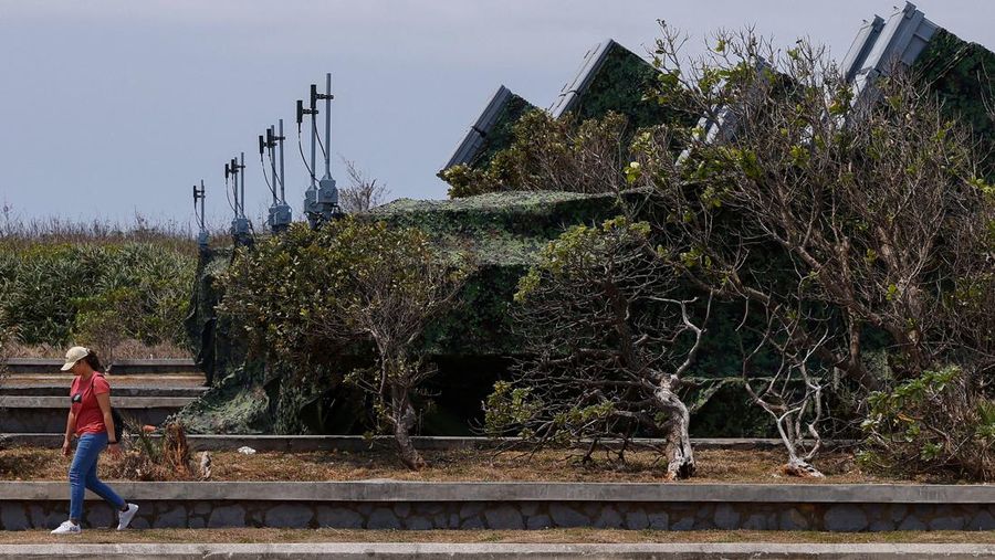 A tourist gets off their bus that is parked in front of Hsiung Feng mobile missile launchers at Cape Maobitou park in Pingtung County, Taiwan April 10, 2023. REUTERS/Ann Wang