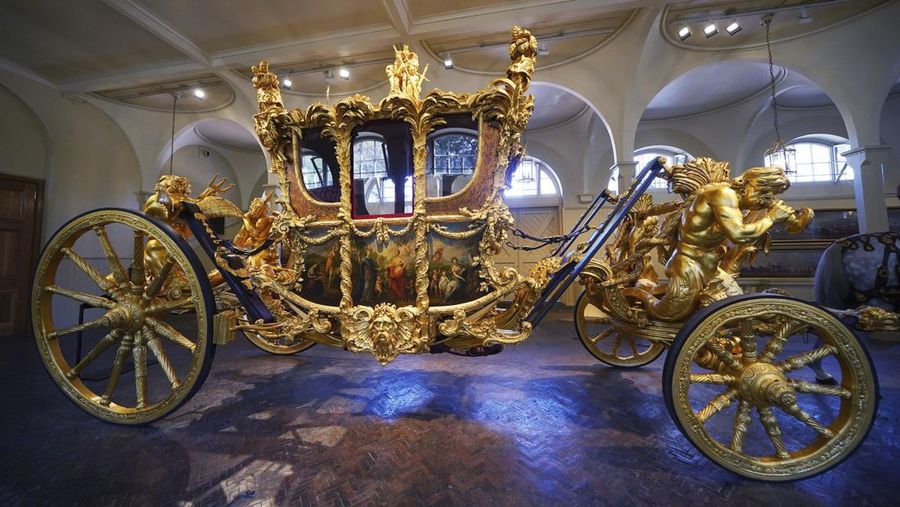 The Diamond Jubilee State Coach on display at the Royal Mews in Buckingham Palace, London, Tuesday April 4, 2023, in which King Charles III and the Queen Consort will travel to the coronation. King Charles III is taking a short cut and smoother ride to Westminster Abbey, trimming the procession route his mother took in 1953 as he aims for a more modest coronation that will include some modern touches, Buckingham Palace said Sunday April 9, 2023. (Yui Mok/PA via AP)
