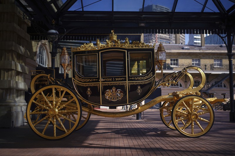King Charles III Coronation The Diamond Jubilee State Coach on display at the Royal Mews in Buckingham Palace, London, Tuesday April 4, 2023, in which King Charles III and the Queen Consort will travel to the coronation. King Charles III is taking a short cut and smoother ride to Westminster Abbey, trimming the procession route his mother took in 1953 as he aims for a more modest coronation that will include some modern touches, Buckingham Palace said Sunday April 9, 2023. (Yui Mok/PA via AP)