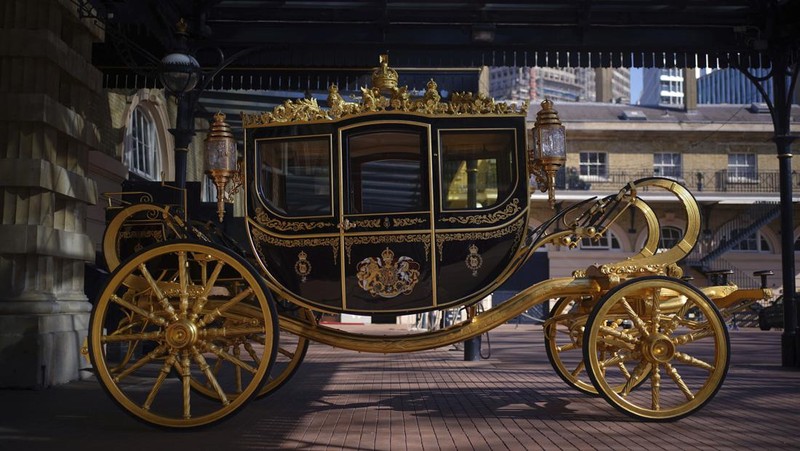 The Diamond Jubilee State Coach on display at the Royal Mews in Buckingham Palace, London, Tuesday April 4, 2023, in which King Charles III and the Queen Consort will travel to the coronation. King Charles III is taking a short cut and smoother ride to Westminster Abbey, trimming the procession route his mother took in 1953 as he aims for a more modest coronation that will include some modern touches, Buckingham Palace said Sunday April 9, 2023. (Yui Mok/PA via AP)
