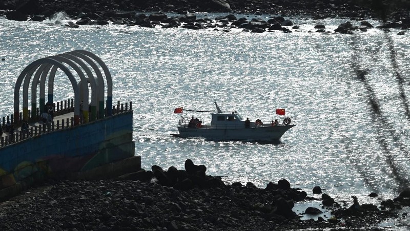 Sebuah kapal wisata berlayar di sepanjang pantai pulau Pingtan, di seberang Taiwan, di provinsi Fujian tenggara China pada 9 April 2023. - China melakukan latihan militer hari kedua di sekitar Taiwan pada 9 April, dalam apa yang disebutnya 