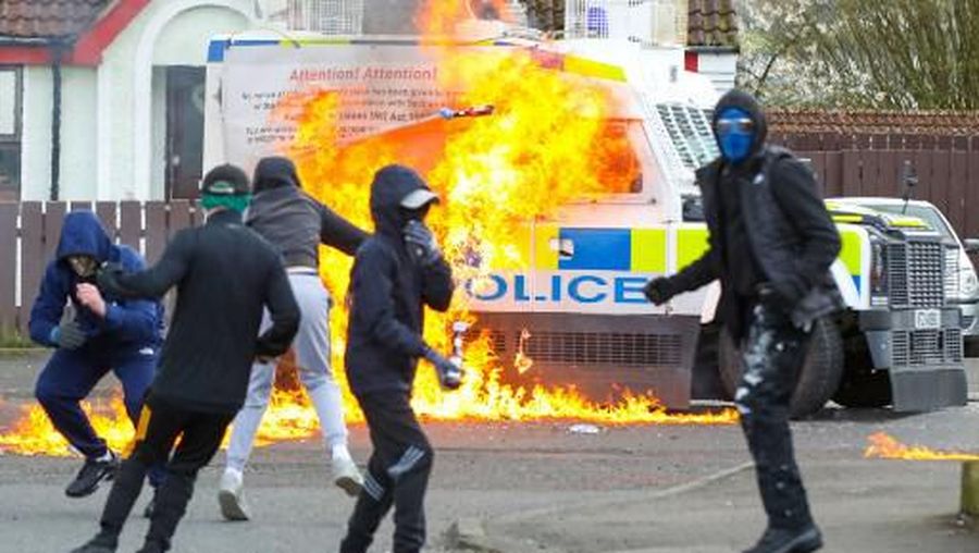 Masked youths attack a Police landrover with petrol bombs  after Republicans took part in a march to commemorate the 1916 Easter Rising, in the Creggan area of Derry (Londonderry) in Northern Ireland on April 5, 2023. (Photo by PAUL FAITH / AFP)