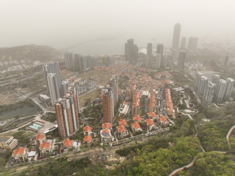 Distrik pesisir timur terlihat dalam debu yang mengambang di Kota Lianyungang, provinsi Jiangsu, China Timur pada 11 April 2023. (CFOTO/Future Publishing via Getty Images)