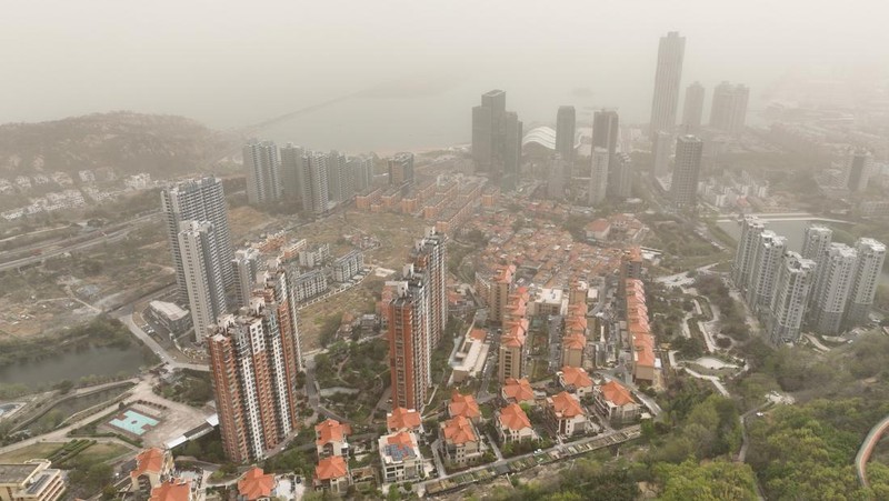 Distrik pesisir timur terlihat dalam debu yang mengambang di Kota Lianyungang, provinsi Jiangsu, China Timur pada 11 April 2023. (CFOTO/Future Publishing via Getty Images)