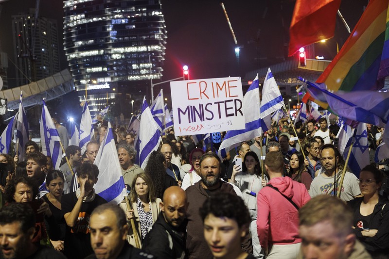 Para pengunjuk rasa saat demonstrasi anti-pemerintah menyusul pidato Perdana Menteri Israel Benjamin Netanyahu di Tel Aviv, Israel, pada Senin, 10 April 2023. Setelah seminggu serangan roket dan penembakan oleh militan Palestina di berbagai front, Perdana Menteri Israel Benjamin Netanyahu mundur dari keputusannya untuk memecat Menteri Pertahanan Yoav Gallant. (Kobi Wolf/Bloomberg via Getty Images)