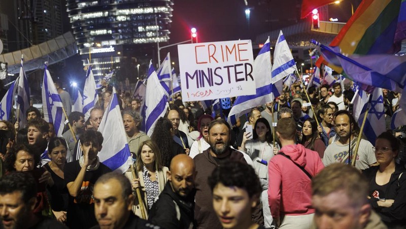 Para pengunjuk rasa saat demonstrasi anti-pemerintah menyusul pidato Perdana Menteri Israel Benjamin Netanyahu di Tel Aviv, Israel, pada Senin, 10 April 2023. Setelah seminggu serangan roket dan penembakan oleh militan Palestina di berbagai front, Perdana Menteri Israel Benjamin Netanyahu mundur dari keputusannya untuk memecat Menteri Pertahanan Yoav Gallant. (Kobi Wolf/Bloomberg via Getty Images)