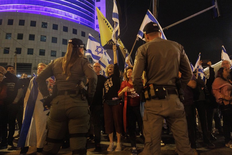 Para pengunjuk rasa saat demonstrasi anti-pemerintah menyusul pidato Perdana Menteri Israel Benjamin Netanyahu di Tel Aviv, Israel, pada Senin, 10 April 2023. Setelah seminggu serangan roket dan penembakan oleh militan Palestina di berbagai front, Perdana Menteri Israel Benjamin Netanyahu mundur dari keputusannya untuk memecat Menteri Pertahanan Yoav Gallant. (Kobi Wolf/Bloomberg via Getty Images)