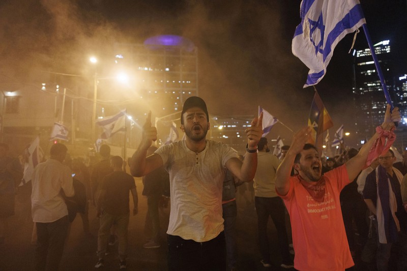 Para pengunjuk rasa saat demonstrasi anti-pemerintah menyusul pidato Perdana Menteri Israel Benjamin Netanyahu di Tel Aviv, Israel, pada Senin, 10 April 2023. Setelah seminggu serangan roket dan penembakan oleh militan Palestina di berbagai front, Perdana Menteri Israel Benjamin Netanyahu mundur dari keputusannya untuk memecat Menteri Pertahanan Yoav Gallant. (Kobi Wolf/Bloomberg via Getty Images)