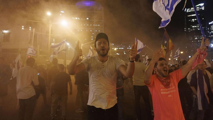 Para pengunjuk rasa saat demonstrasi anti-pemerintah menyusul pidato Perdana Menteri Israel Benjamin Netanyahu di Tel Aviv, Israel, pada Senin, 10 April 2023. Setelah seminggu serangan roket dan penembakan oleh militan Palestina di berbagai front, Perdana Menteri Israel Benjamin Netanyahu mundur dari keputusannya untuk memecat Menteri Pertahanan Yoav Gallant. (Kobi Wolf/Bloomberg via Getty Images)