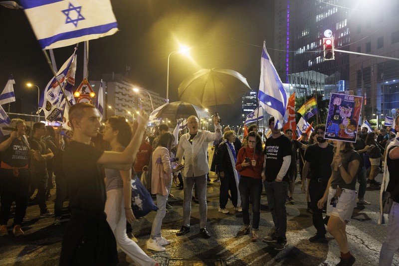 Para pengunjuk rasa saat demonstrasi anti-pemerintah menyusul pidato Perdana Menteri Israel Benjamin Netanyahu di Tel Aviv, Israel, pada Senin, 10 April 2023. Setelah seminggu serangan roket dan penembakan oleh militan Palestina di berbagai front, Perdana Menteri Israel Benjamin Netanyahu mundur dari keputusannya untuk memecat Menteri Pertahanan Yoav Gallant. (Kobi Wolf/Bloomberg via Getty Images)