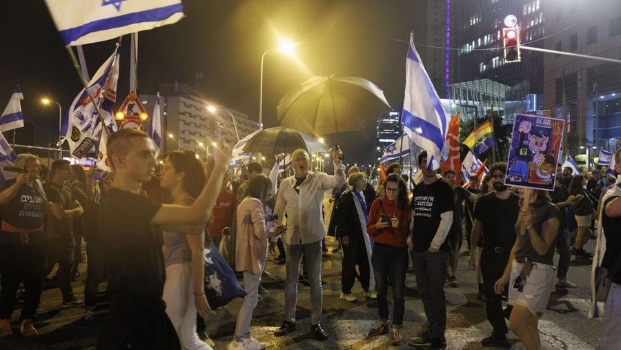 Para pengunjuk rasa saat demonstrasi anti-pemerintah menyusul pidato Perdana Menteri Israel Benjamin Netanyahu di Tel Aviv, Israel, pada Senin, 10 April 2023. Setelah seminggu serangan roket dan penembakan oleh militan Palestina di berbagai front, Perdana Menteri Israel Benjamin Netanyahu mundur dari keputusannya untuk memecat Menteri Pertahanan Yoav Gallant. (Kobi Wolf/Bloomberg via Getty Images)