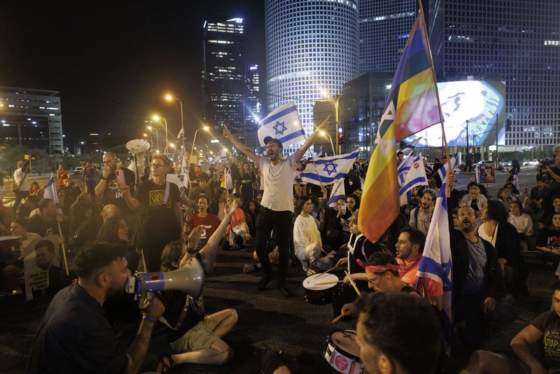 Para pengunjuk rasa saat demonstrasi anti-pemerintah menyusul pidato Perdana Menteri Israel Benjamin Netanyahu di Tel Aviv, Israel, pada Senin, 10 April 2023. Setelah seminggu serangan roket dan penembakan oleh militan Palestina di berbagai front, Perdana Menteri Israel Benjamin Netanyahu mundur dari keputusannya untuk memecat Menteri Pertahanan Yoav Gallant. (Kobi Wolf/Bloomberg via Getty Images)