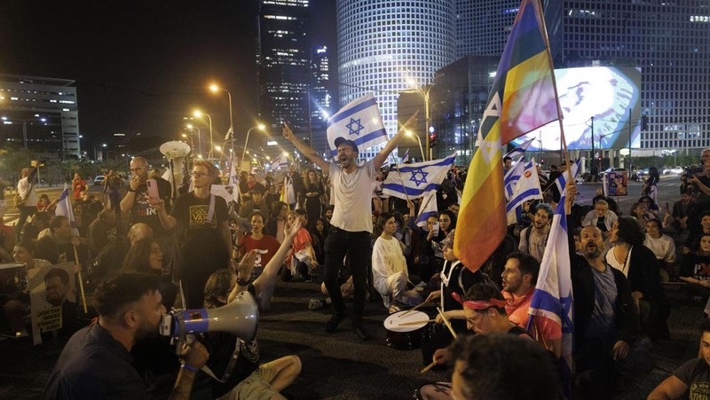 Para pengunjuk rasa saat demonstrasi anti-pemerintah menyusul pidato Perdana Menteri Israel Benjamin Netanyahu di Tel Aviv, Israel, pada Senin, 10 April 2023. Setelah seminggu serangan roket dan penembakan oleh militan Palestina di berbagai front, Perdana Menteri Israel Benjamin Netanyahu mundur dari keputusannya untuk memecat Menteri Pertahanan Yoav Gallant. (Kobi Wolf/Bloomberg via Getty Images)